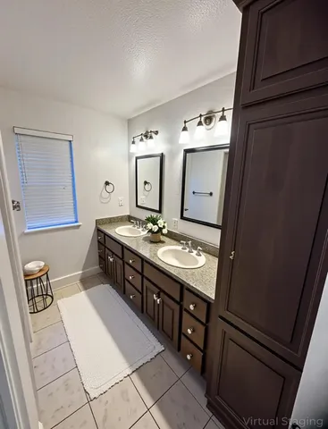 a bathroom with double vanity and a mirror