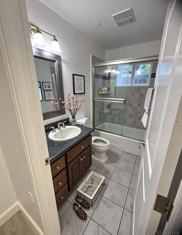 a bathroom with a sink a toilet a mirror and shower