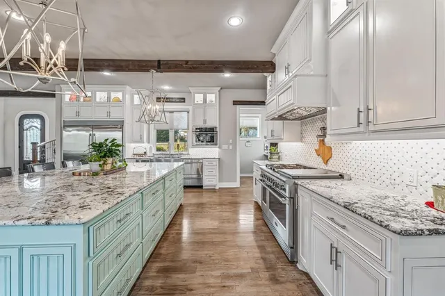 a kitchen with stainless steel appliances granite countertop a sink and stove