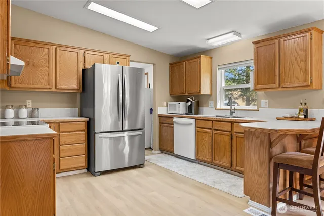 a kitchen with stainless steel appliances granite countertop a refrigerator sink and cabinets