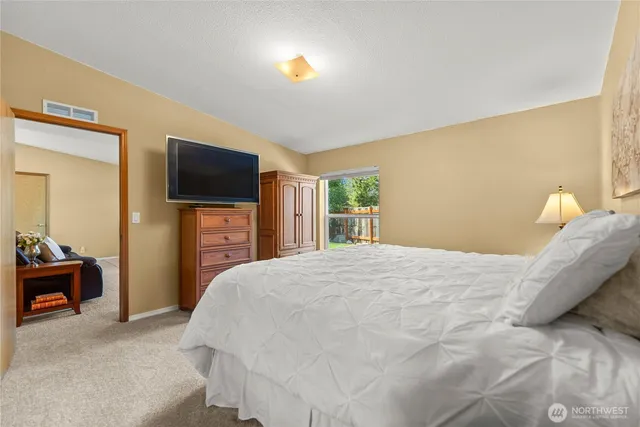 a bedroom with a bed and a flat screen tv