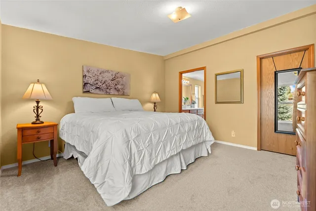 a spacious bedroom with a bed and a painting on the wall