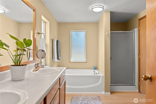 a bathroom with a granite countertop sink and a bathtub