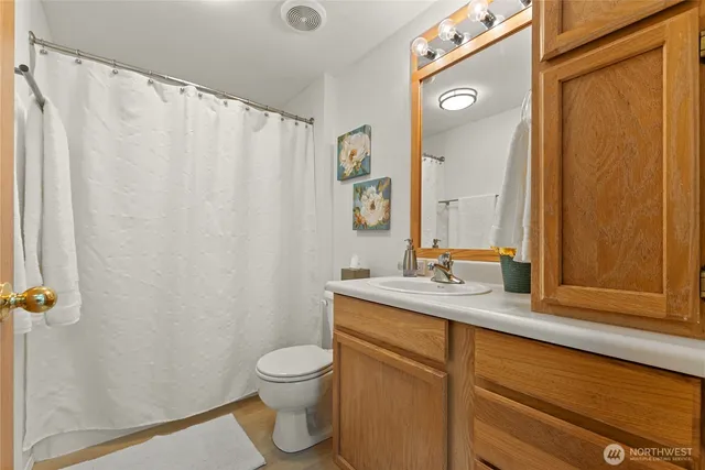 a bathroom with a granite countertop sink toilet and mirror