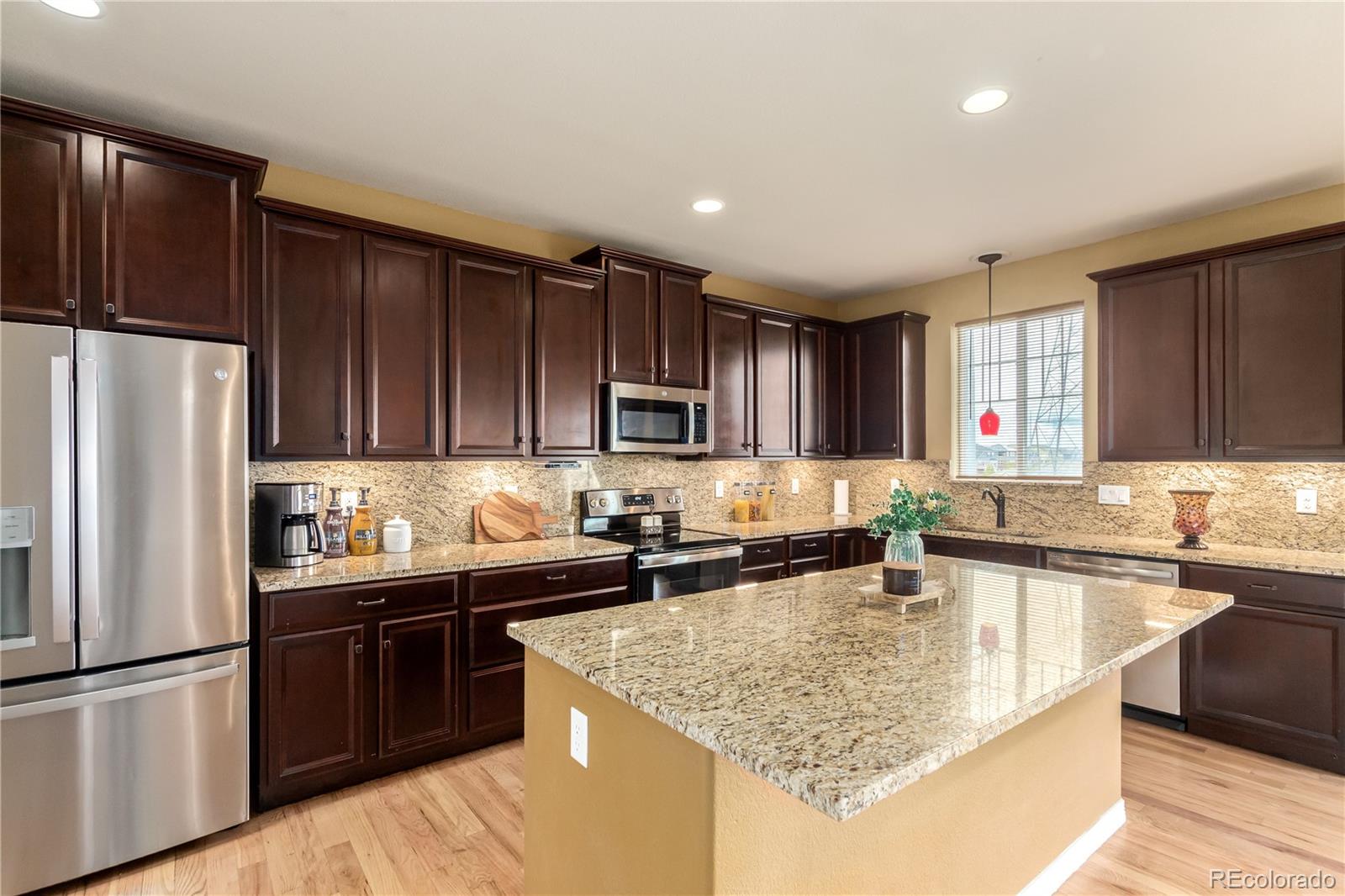24389 East Brandt Avenue Aurora, CO 80016 - Photo 13 of 49 a kitchen with stainless steel appliances granite countertop a sink stove and refrigerator