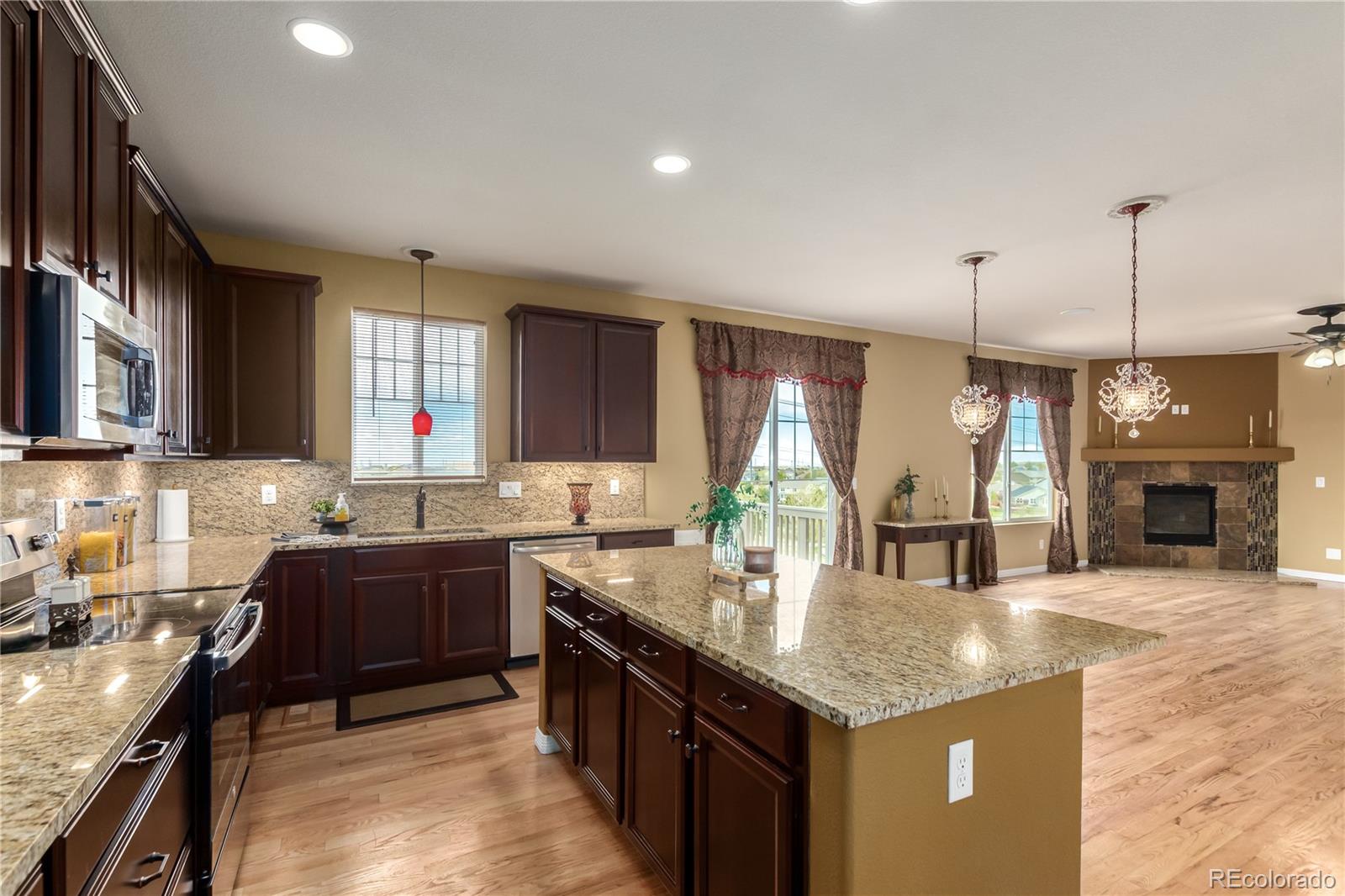 24389 East Brandt Avenue Aurora, CO 80016 - Photo 14 of 49 a kitchen with granite countertop a sink stove and cabinets