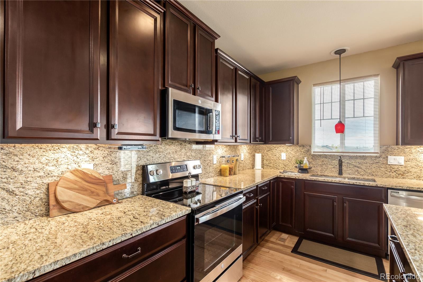 24389 East Brandt Avenue Aurora, CO 80016 - Photo 15 of 49 a kitchen with stainless steel appliances granite countertop a sink stove and microwave