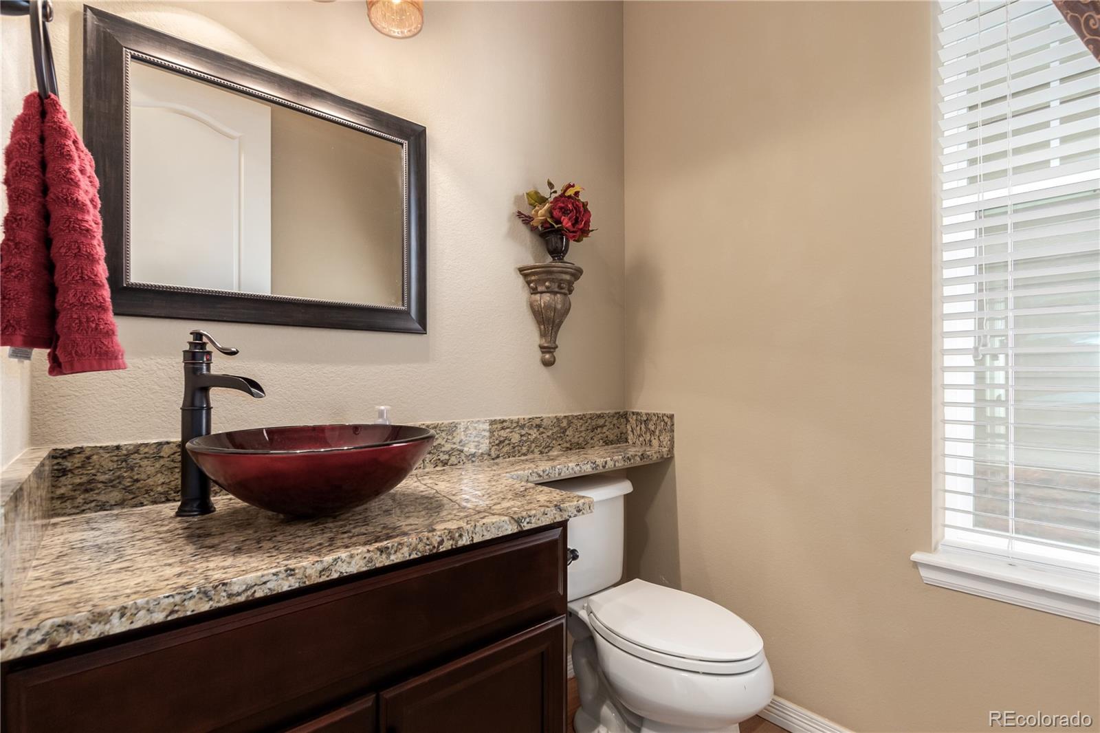 24389 East Brandt Avenue Aurora, CO 80016 - Photo 18 of 49 a bathroom with a granite countertop toilet sink and mirror