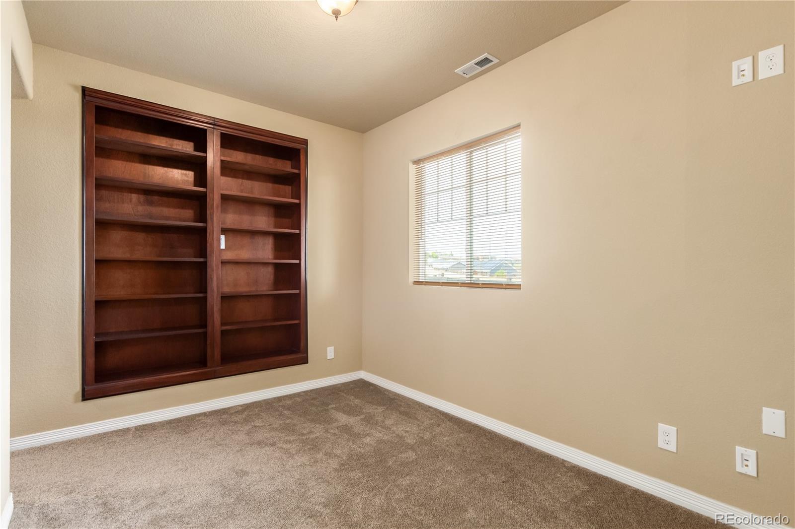24389 East Brandt Avenue Aurora, CO 80016 - Photo 26 of 49 a view of an empty room with a fireplace and a window