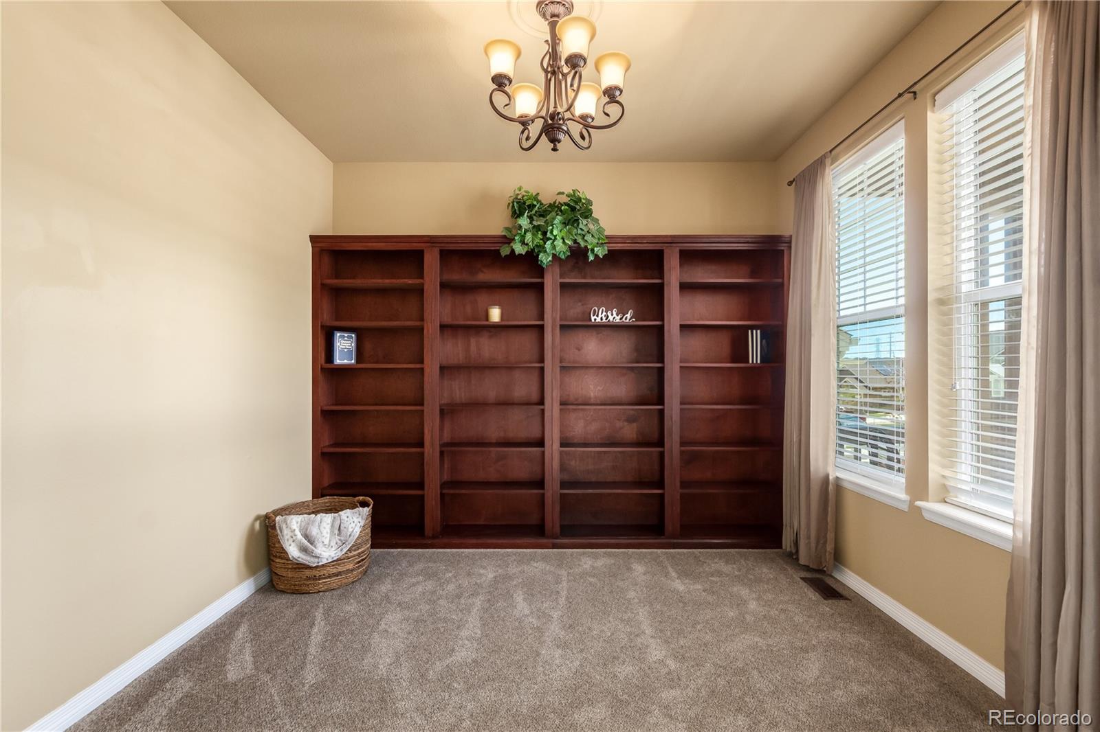 24389 East Brandt Avenue Aurora, CO 80016 - Photo 7 of 49 a view of empty room with wooden floor and windows