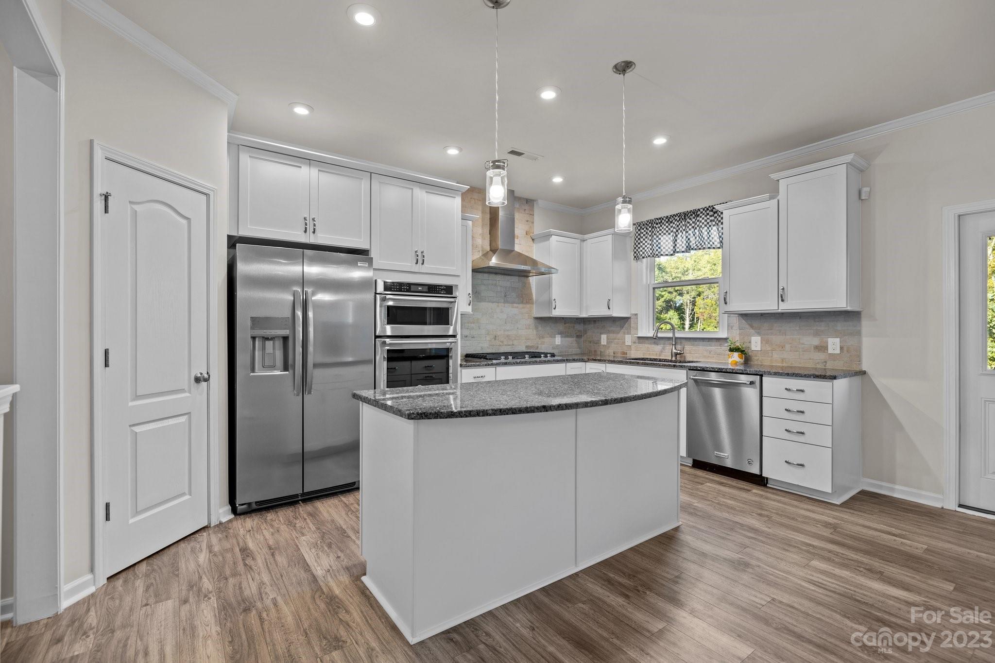 137 Hampton Trail Drive Fort Mill, SC 29708 - Photo 17 of 48 a kitchen with stainless steel appliances granite countertop a refrigerator a sink dishwasher a stove and white cabinets with wooden floor