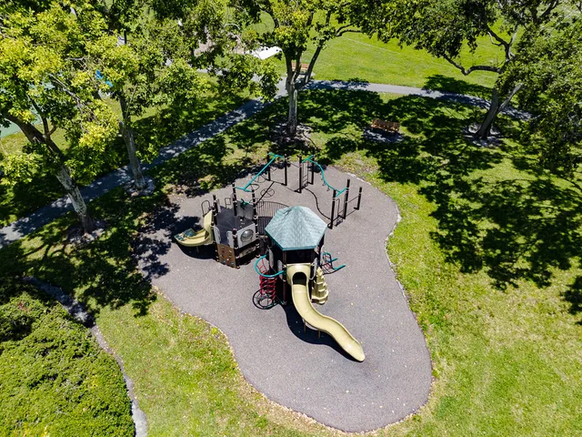 a sign board with a house and yard at the back
