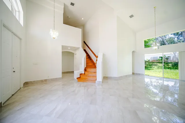 a view of an empty room with a floor to ceiling window and stairs