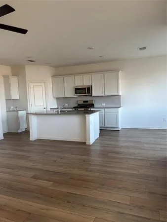 a kitchen with granite countertop a stove and a wooden floors