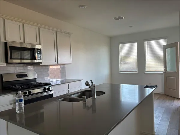 a kitchen with a sink stainless steel appliances and cabinets