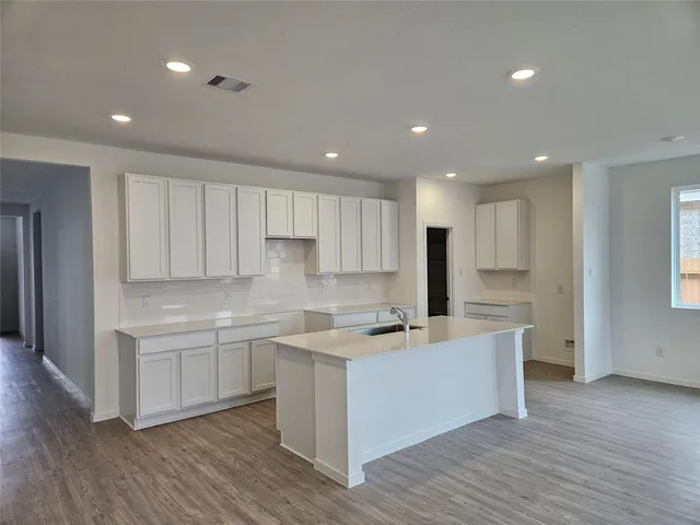 an open kitchen view with wooden floor and large windows