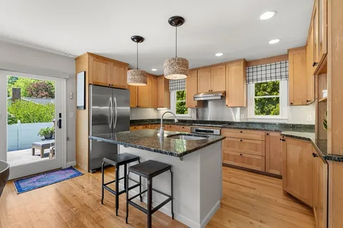 a kitchen with stainless steel appliances granite countertop a sink refrigerator and cabinets
