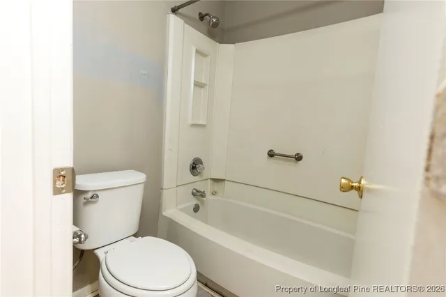 a white toilet sitting next to a bath tub