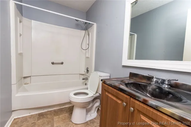 a bathroom with a bathtub shower sink vanity and toilet