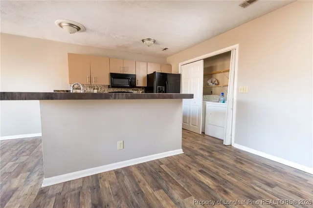 a living room with stainless steel appliances wooden floor and view living room