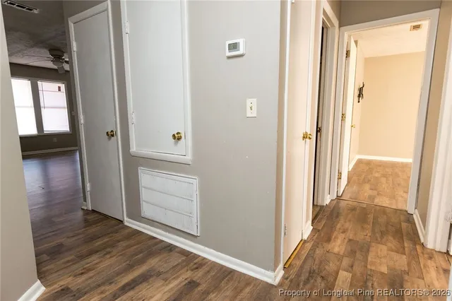 a view of a hallway with wooden floor and closet