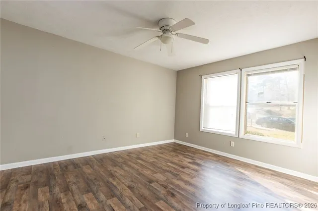 an empty room with a window and a ceiling fan
