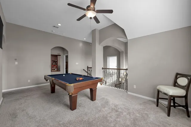 a room with pool table and windows