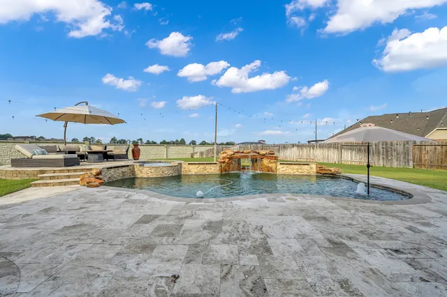 a swimming pool with outdoor seating and yard
