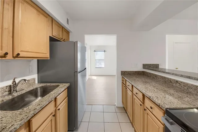 a kitchen with stainless steel appliances granite countertop a sink stove and refrigerator