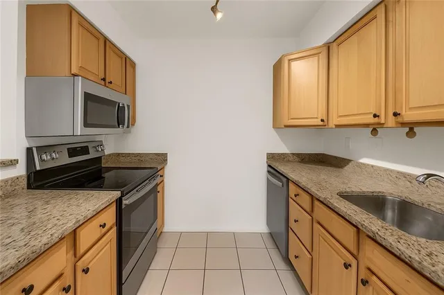 a kitchen with granite countertop a sink a stove and cabinets