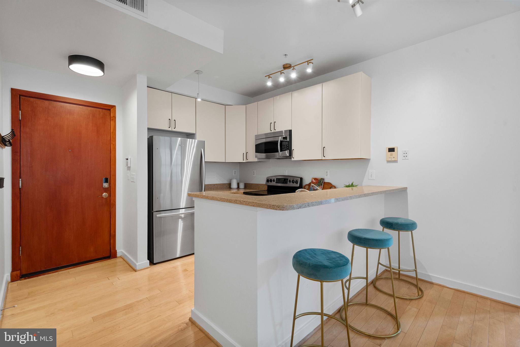 2412 17th Street Northwest, Unit 102 Washington, DC 20009 - Photo 2 of 21 a kitchen with stainless steel appliances granite countertop a refrigerator a stove a sink dishwasher and a refrigerator with wooden floor