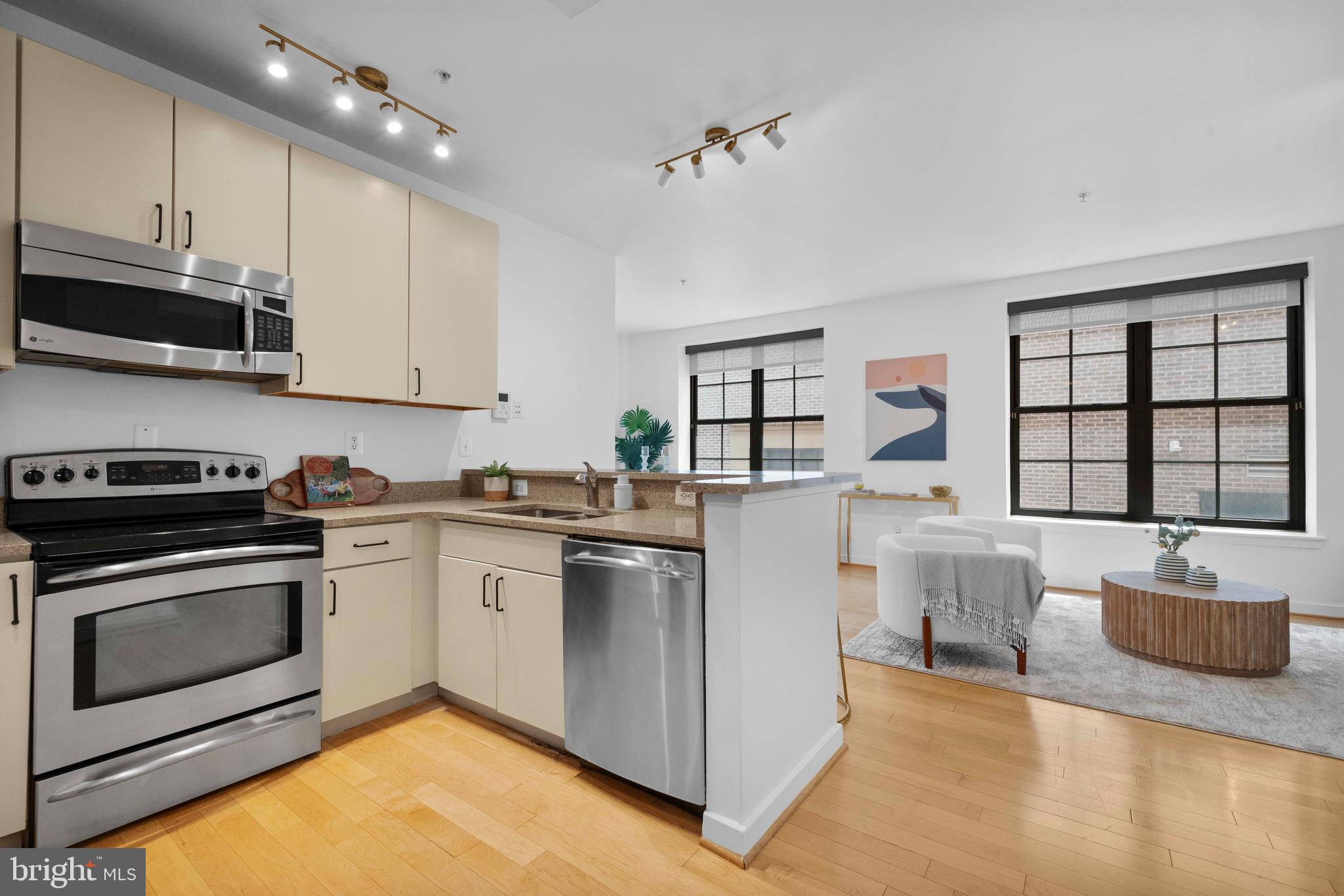 2412 17th Street Northwest, Unit 102 Washington, DC 20009 - Photo 3 of 21 a kitchen with stainless steel appliances granite countertop a stove top oven a sink dishwasher and white cabinets with wooden floor