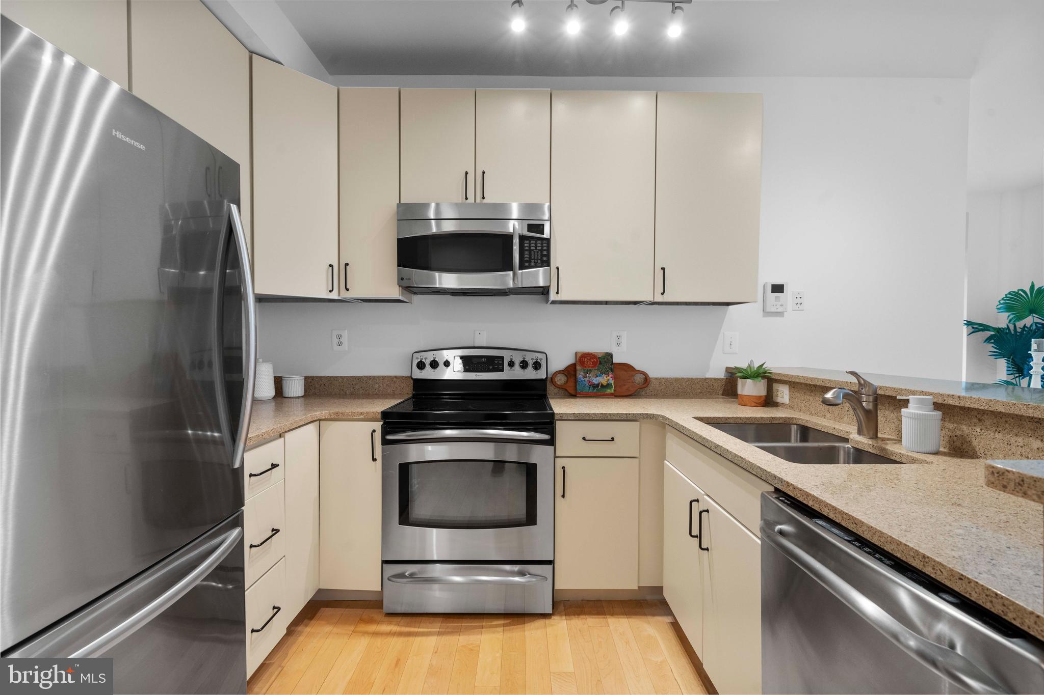 2412 17th Street Northwest, Unit 102 Washington, DC 20009 - Photo 4 of 21 a kitchen with stainless steel appliances granite countertop white cabinets a sink a stove a refrigerator and white cabinets