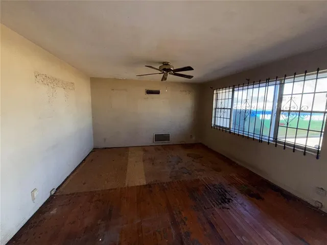 wooden floor in an empty room with a window