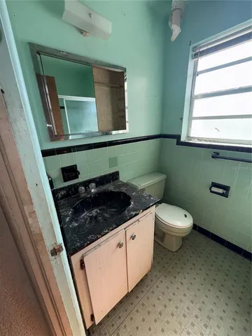 a bathroom with a toilet a sink and a window