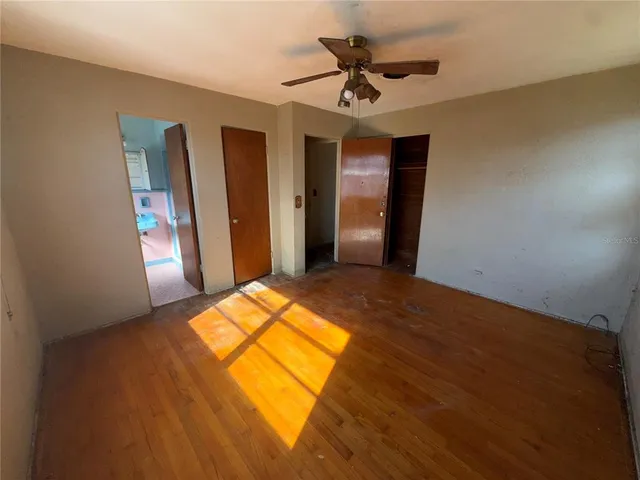 a view of a room with wooden floor and ceiling fan