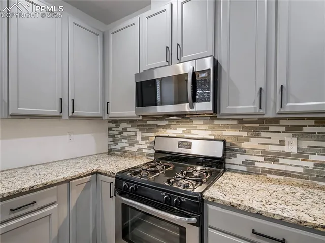 a kitchen with granite countertop a stove sink and cabinets