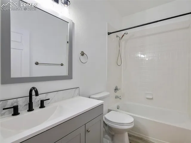 a view of a white house with large windows next to a road