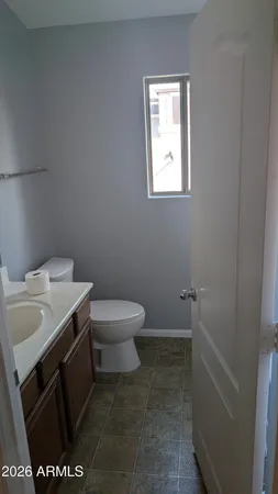 a bathroom with a sink toilet and window