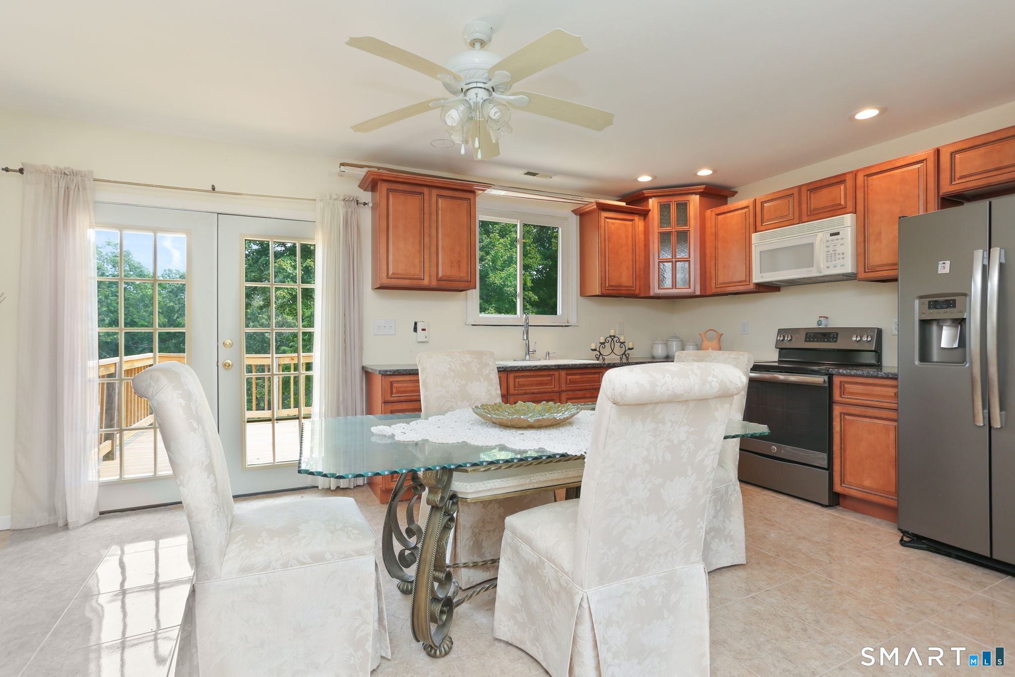 421 Strong Street East Haven, CT 06512 - Photo 13 of 30 a kitchen with stainless steel appliances granite countertop a stove top oven a refrigerator a sink dishwasher a dining table and chairs with wooden floor