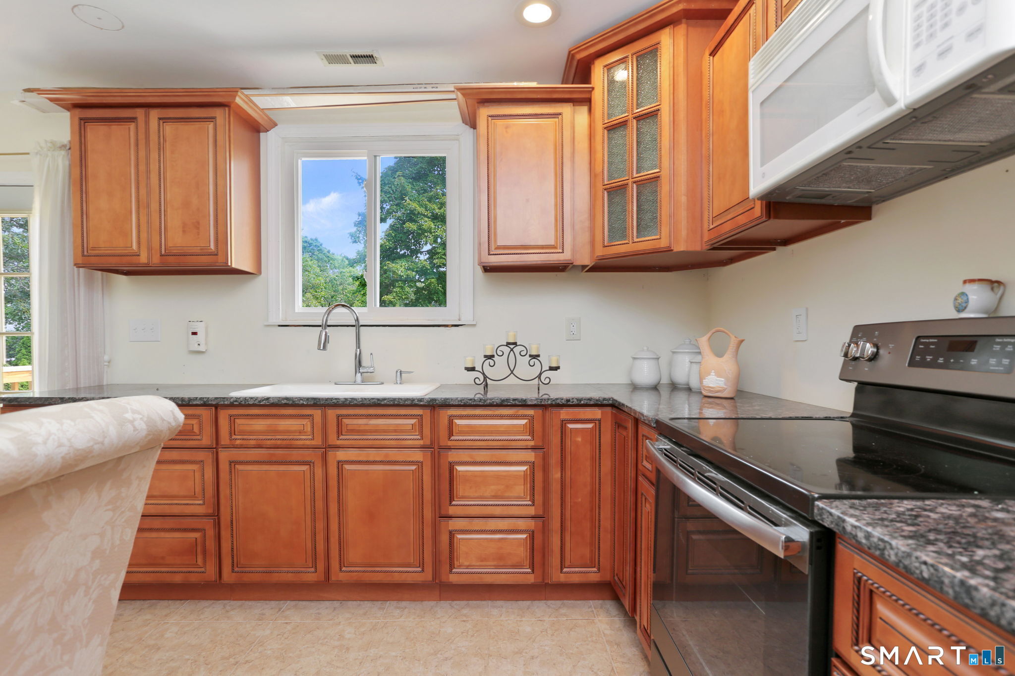 421 Strong Street East Haven, CT 06512 - Photo 14 of 30 a kitchen with stainless steel appliances granite countertop a stove a sink and a microwave