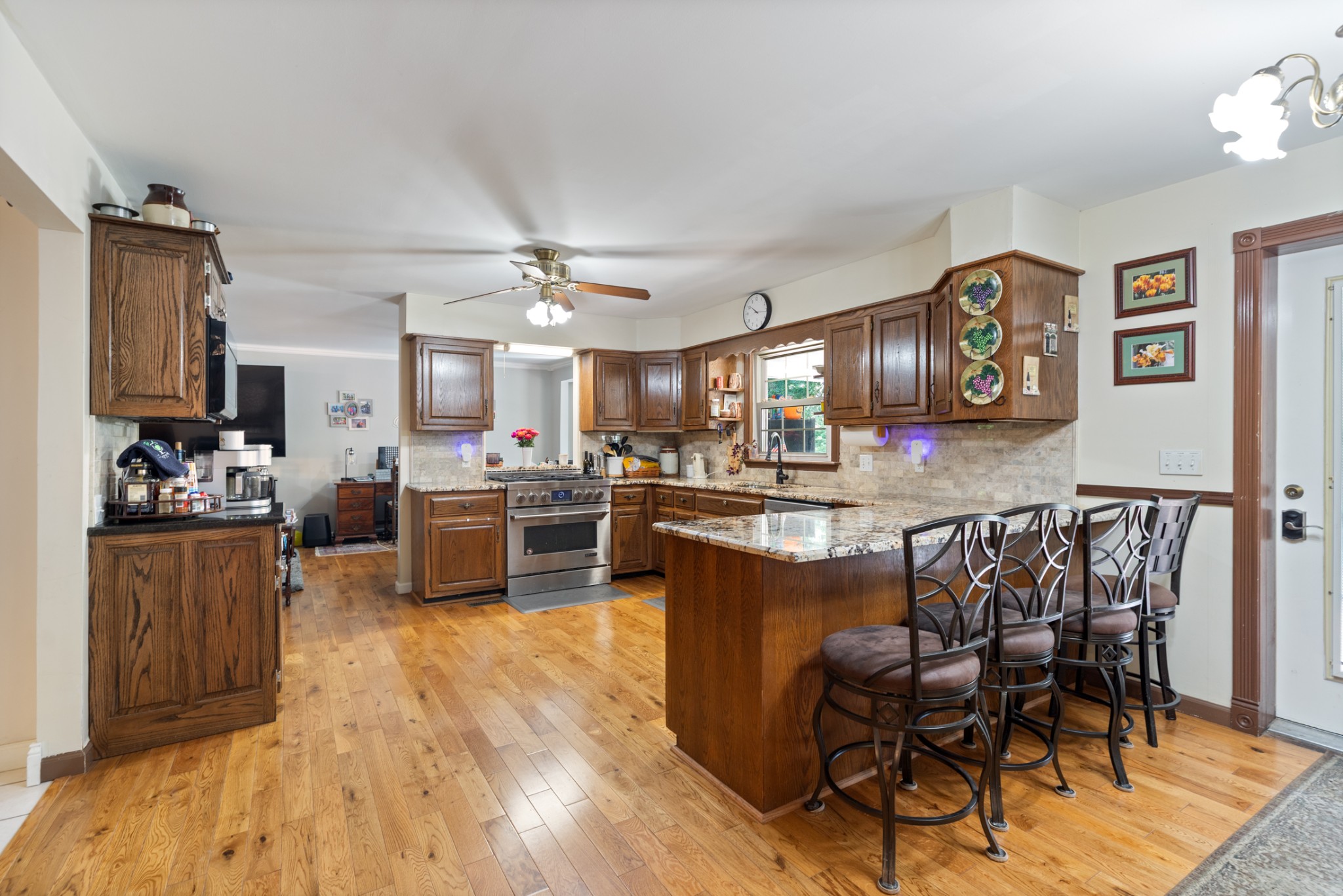 7422 Indian Creek Road McEwen, TN 37101 - Photo 24 of 71 a kitchen with stainless steel appliances kitchen island granite countertop a refrigerator a stove a sink a dining table and chairs with wooden floor