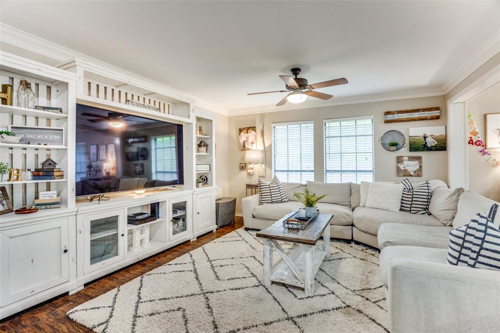 a living room with furniture two window and a kitchen