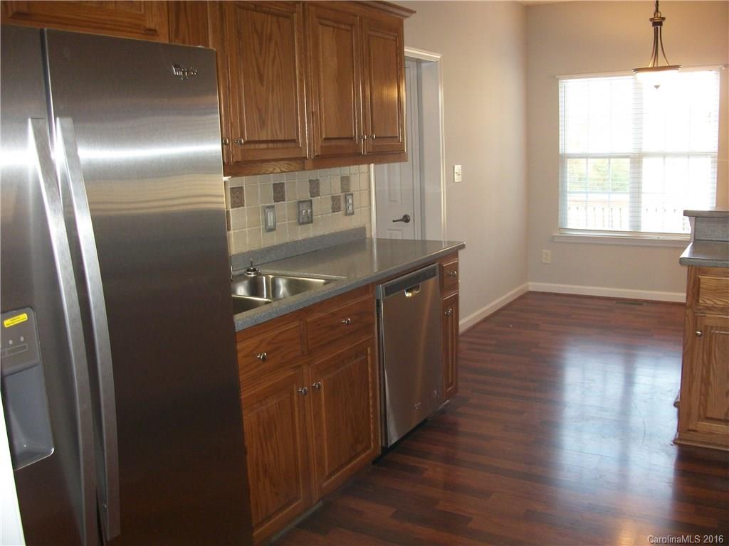 2118 Doster Road, Unit 1 Monroe, NC 28112 - Photo 11 of 24 a kitchen with stainless steel appliances granite countertop a refrigerator a sink and wooden cabinets
