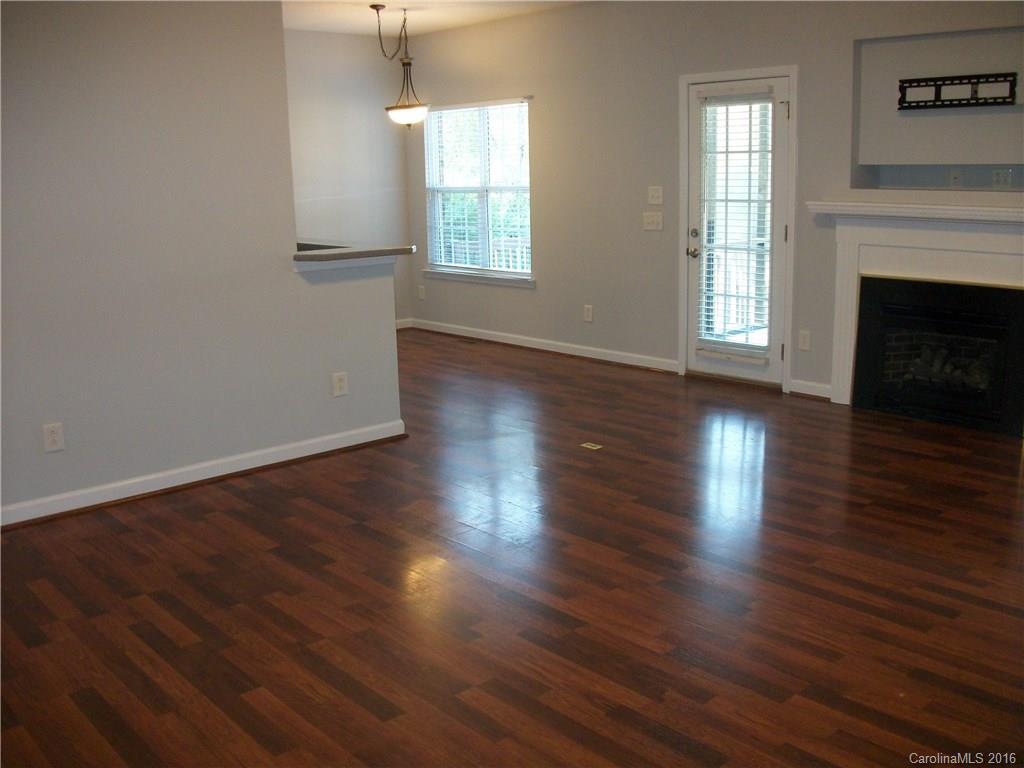 2118 Doster Road, Unit 1 Monroe, NC 28112 - Photo 5 of 24 an empty room with wooden floor fireplace and windows