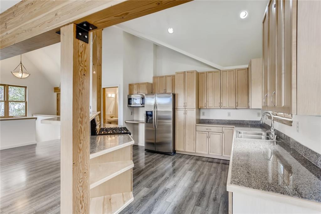 27 Rasor Court Keystone, CO 80435 - Photo 6 of 30 a kitchen with a refrigerator a sink and wooden cabinets