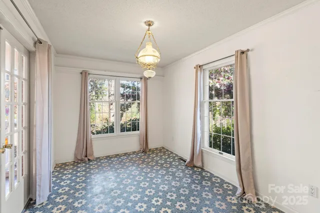 a view of a hallway with windows and chandelier