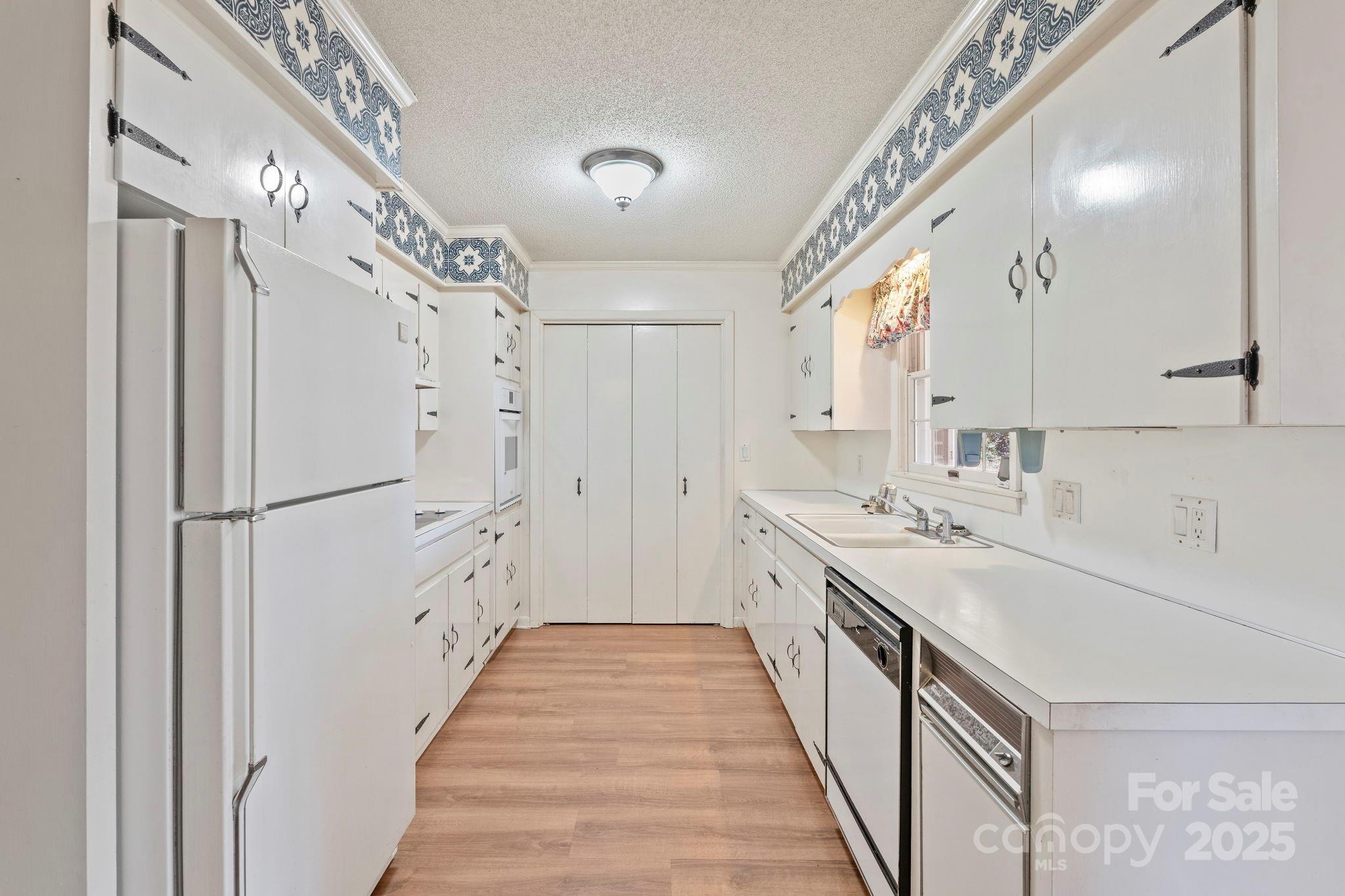 44372 Vickers Store Road Albemarle, NC 28001 - Photo 24 of 42 a kitchen with white cabinets and white appliances