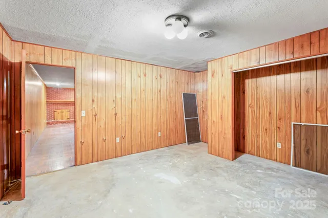 a view of a hallway with a door and wooden floor