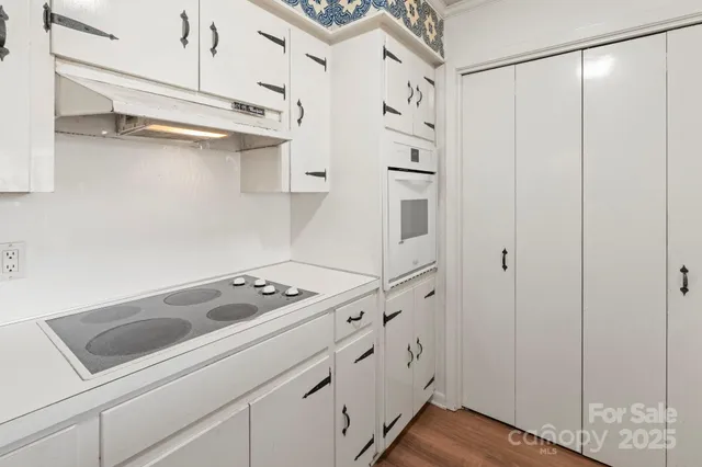 a kitchen with white cabinets and white appliances